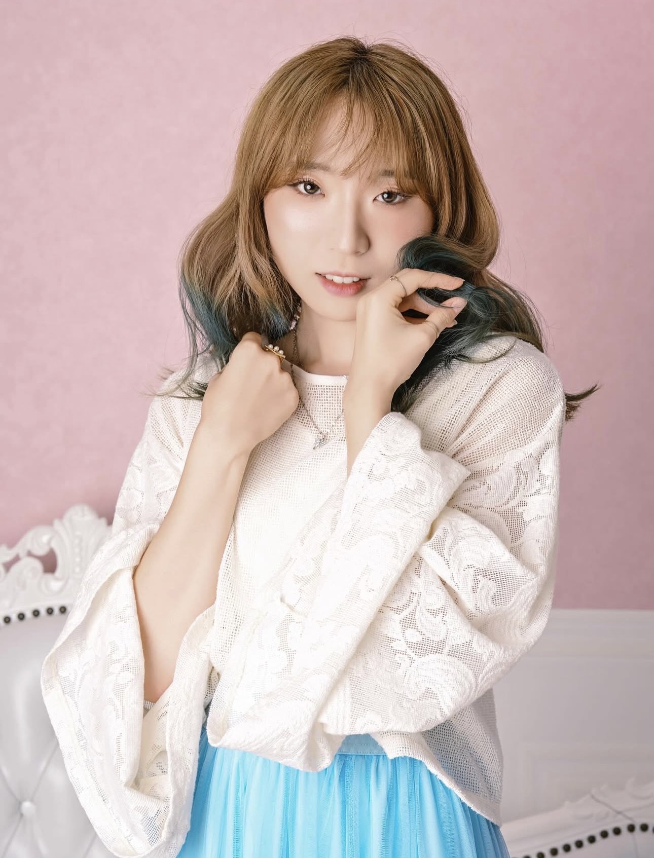 ピンク背景と白い衣装で撮影したガーリーなプロフィール写真