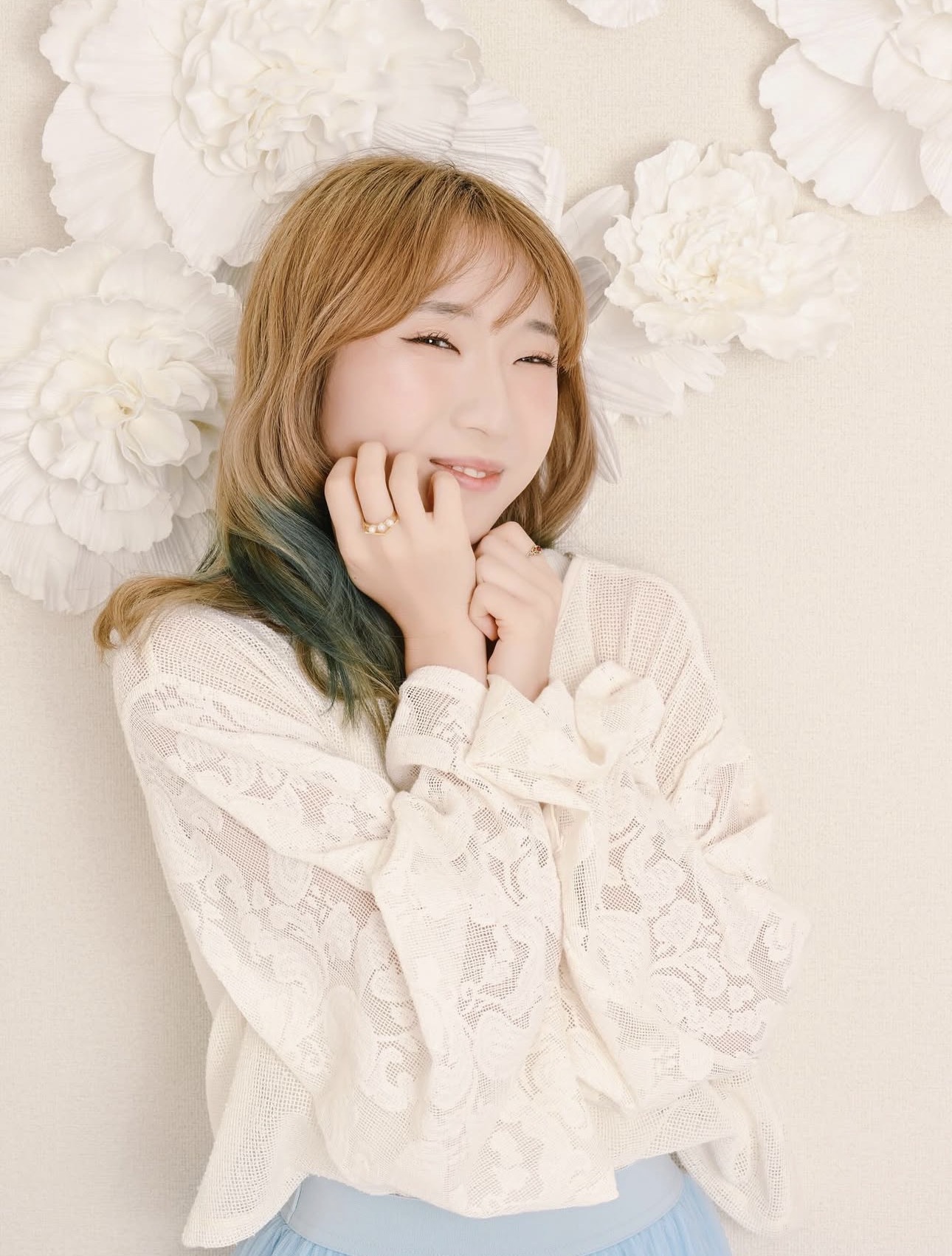 白い花を背景に撮影したプロフィール写真