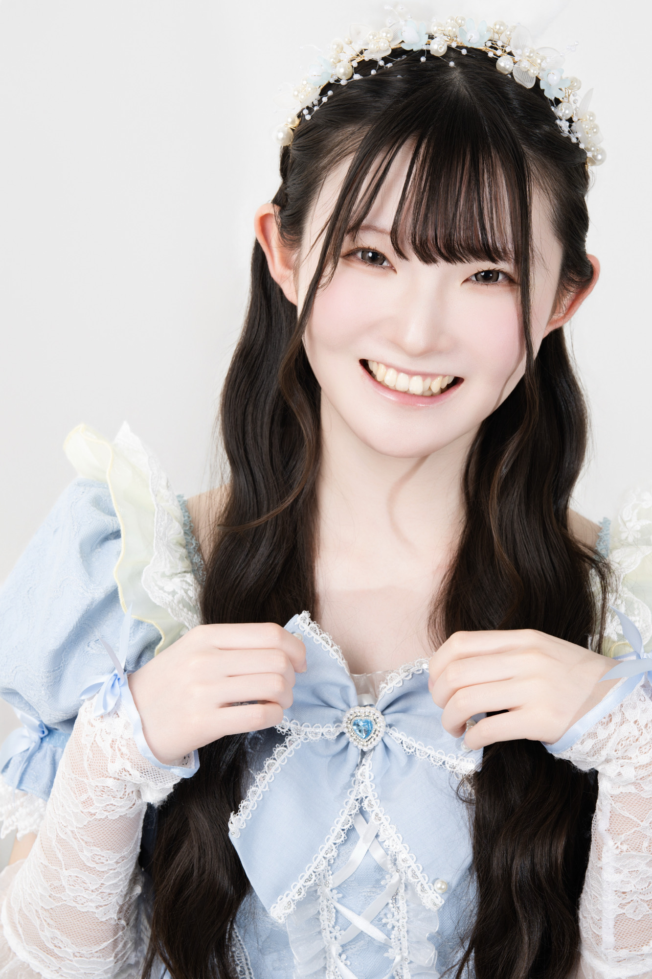 水色衣装で明るく笑うプロフィール写真
