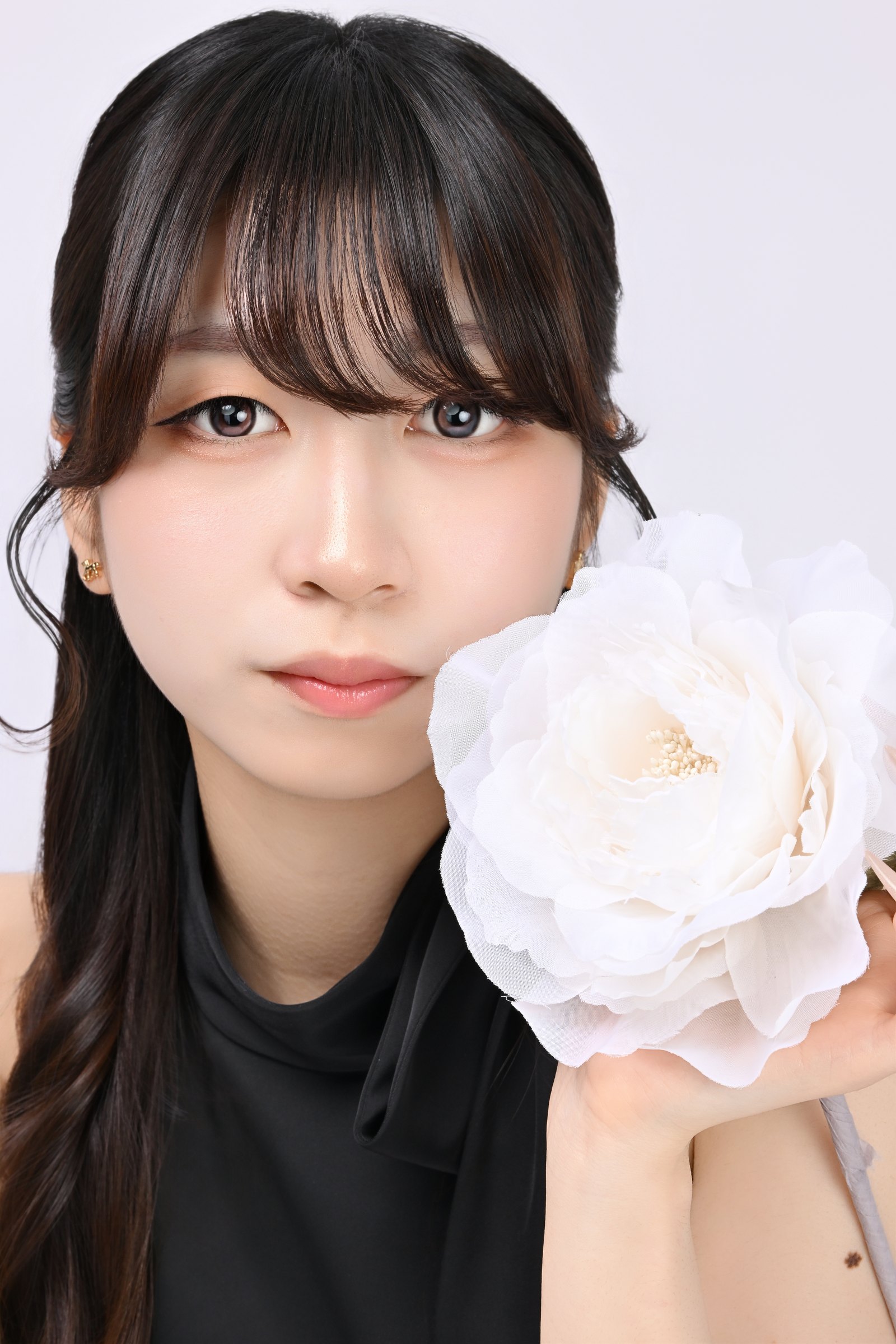 白い花を添えた黒ドレスの華やかな宣材写真